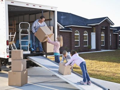 Family-loading-boxes-into-the-back-portion-of-a-moving-truck